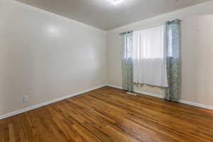 Unfurnished room with baseboards and wood finished floors