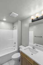 Full bath featuring a textured ceiling, bathing tub / shower combination, vanity, and toilet
