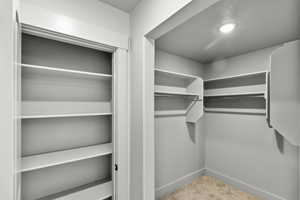 Walk in closet with carpet flooring