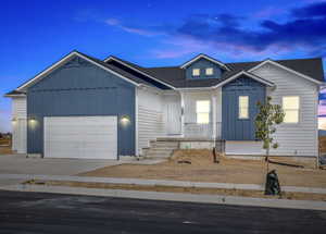 View of front of house with a porch, an attached garage, board and batten siding, and roof with shingles