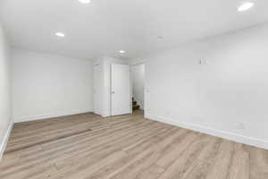 Empty room featuring baseboards, wood finished floors, and recessed lighting