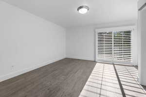 Spare room featuring wood finished floors and baseboards