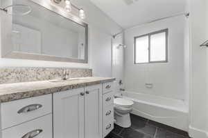 Bathroom featuring tile patterned flooring, vanity, toilet, and shower / bathtub combination