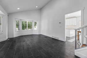 Unfurnished room with vaulted ceiling, recessed lighting, and baseboards
