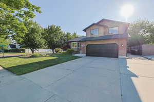 Traditional-style home with an attached garage, concrete driveway, and brick siding
