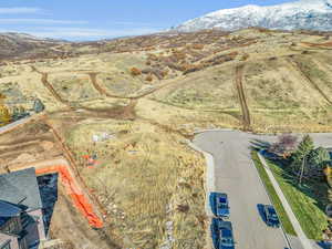 Aerial view of property and surrounding area with a mountain backdrop and property parcel outlined