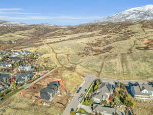 Aerial overview of property's location with a mountainous background and nearby suburban area