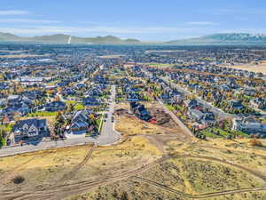 Aerial view of property's location with a mountain backdrop and nearby suburban area