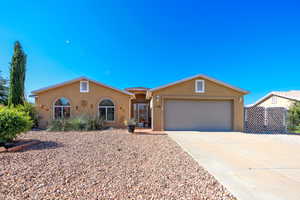 Single story home with stucco siding, a garage, and concrete driveway