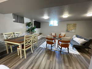 Living area featuring wood finished floors, a textured ceiling, and baseboards
