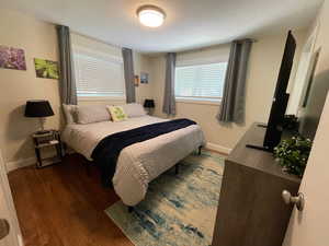 Bedroom with dark wood-type flooring and baseboards