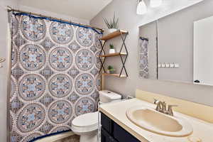 Full bath with toilet, vanity, and a shower with curtain