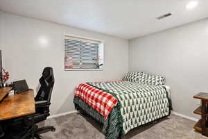 Carpeted bedroom with baseboards and an office area