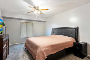 Carpeted bedroom with baseboards and ceiling fan