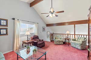 Living room/loft featuring ceiling fan, beamed ceiling, carpet floors, and high vaulted ceiling