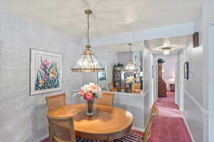 Carpeted dining area featuring easy access to kitchen
