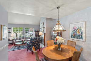 Dining area featuring carpet floors and a textured ceiling