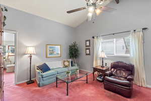 Living room/loft with carpet floors, a ceiling fan, and high vaulted ceiling
