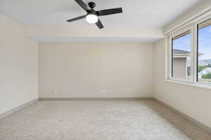 Spare room featuring light colored carpet and ceiling fan