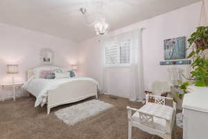 Carpeted bedroom with a chandelier