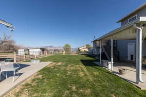 View of yard with stairs, a mountain view, and a patio area