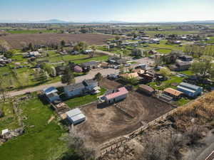 Aerial view of property and surrounding area featuring rural landscape and a mountain backdrop