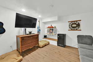 Living area with light wood-style floors, recessed lighting, and baseboards