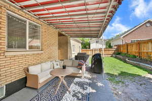 Fenced backyard featuring an outdoor living space and a grill