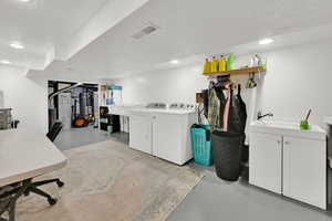 Finished basement with separate washer and dryer, recessed lighting, a textured ceiling, and gas water heater