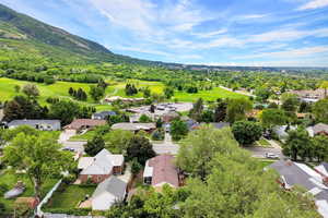 Aerial view of residential area with a mountainous background and a local golf course