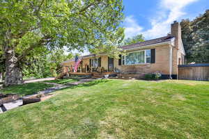 View of front of house with a chimney, brick siding, and a porch