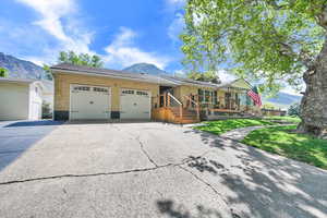 View of front of house featuring an attached garage, a mountain view, brick siding, and concrete driveway