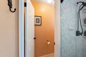 Bathroom featuring baseboards, a shower, and tile patterned flooring