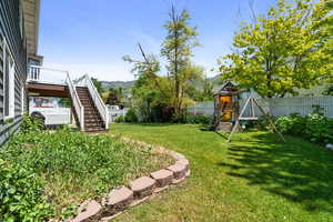 View of yard with a playground, stairs, and a deck with mountain view