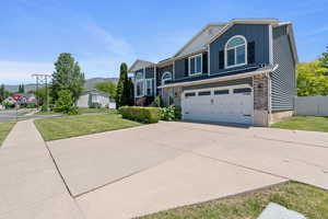 View of front of home with board and batten siding, a garage, driveway, and a mountain view