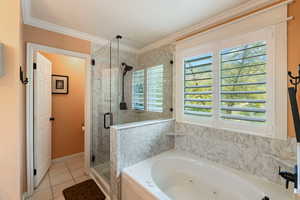 Bathroom featuring a shower stall, a jetted tub, crown molding, and tile patterned floors