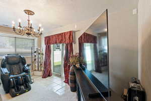 Interior space featuring a chandelier, a textured ceiling, and light tile patterned floors