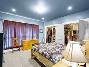 Primary bedroom with carpet, two closets and recessed lighting