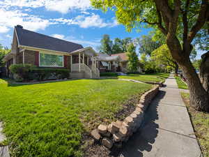 Single story home with brick siding, a front lawn, and a shingled roof