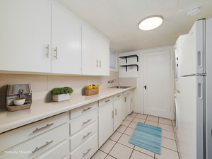 Kitchen with freestanding refrigerator, a sink, white cabinetry, and light tile patterned floors