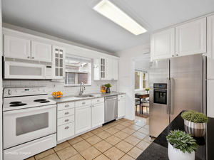 Kitchen featuring appliances with stainless steel finishes, a sink, healthy amount of natural light, and tasteful backsplash