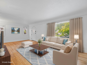 Living room featuring baseboards, wood finished floors, and a textured ceiling