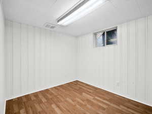 Finished below grade area featuring light wood-type flooring and visible vents