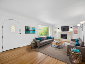 Living area with a glass covered fireplace, wood finished floors, and a wealth of natural light