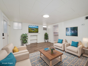 Living room featuring wood finished floors and a wall unit AC