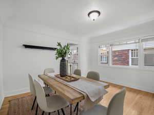 Dining area with light wood-style floors and a textured ceiling