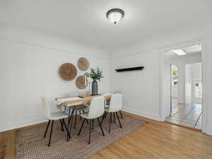 Dining area featuring wood finished floors, arched walkways, and a textured ceiling