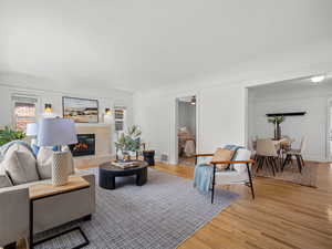 Living room featuring a textured ceiling, light wood finished floors, and a fireplace