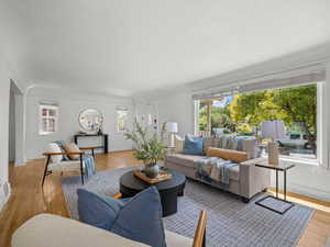 Living area with a textured ceiling, healthy amount of natural light, and light wood-type flooring