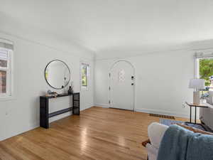 Living area featuring healthy amount of natural light, light wood-type flooring, and a textured ceiling
